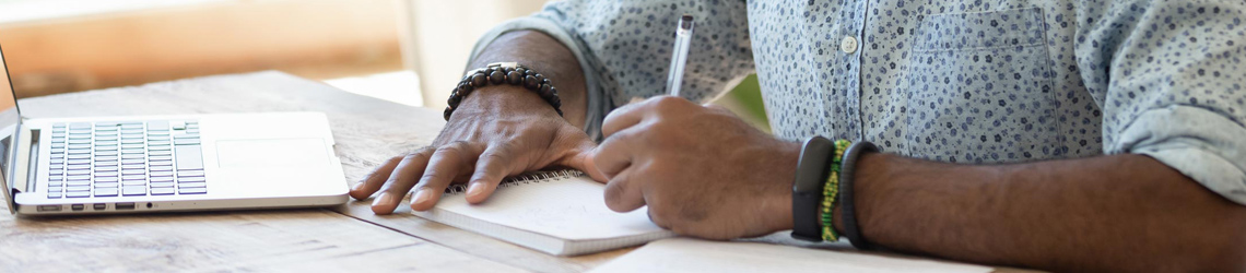 person writing at a computer