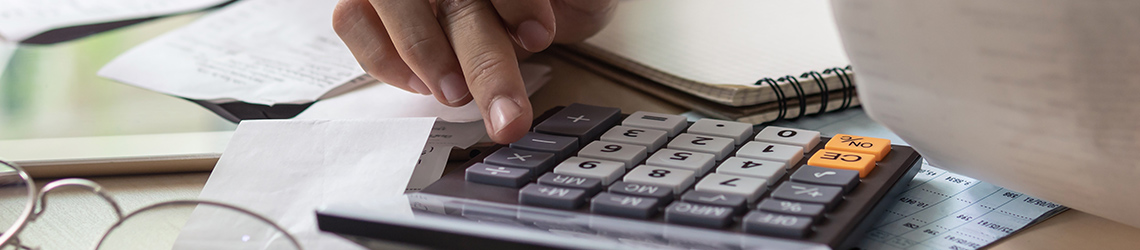 person at desk with calculator